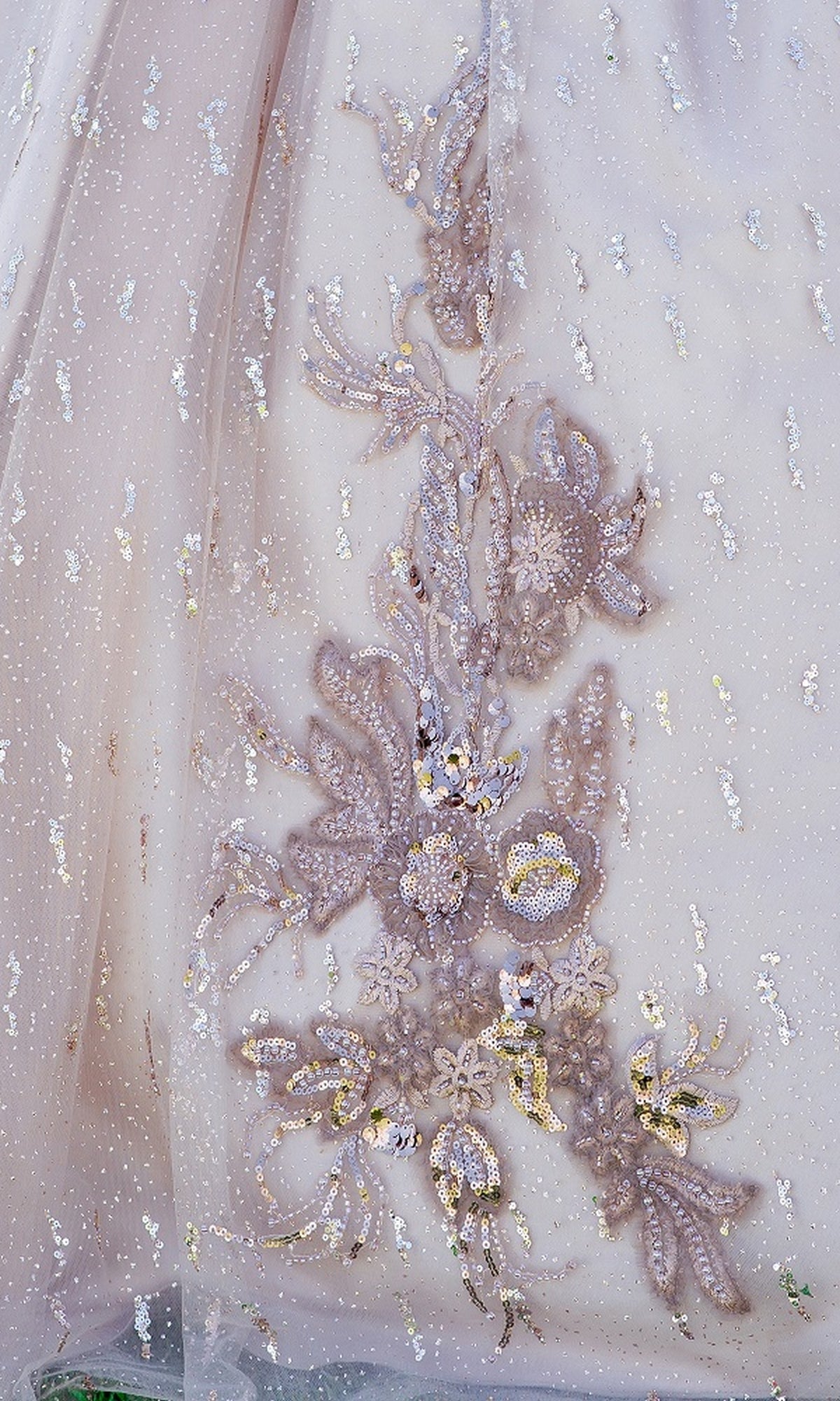 Close-up of glitter tulle with silver and gold floral embroidery and sequins, creating a delicate pattern—ideal for the Quinceanera Ball Gown 8087J, perfect for elegant off-the-shoulder celebrations.
